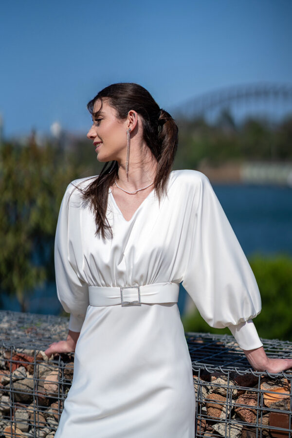 Woman posing in the stunning Erin wedding dress with sleeves by Roya Javaheri