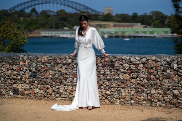 Woman posing in the stunning Erin wedding gown by Roya Javaheri