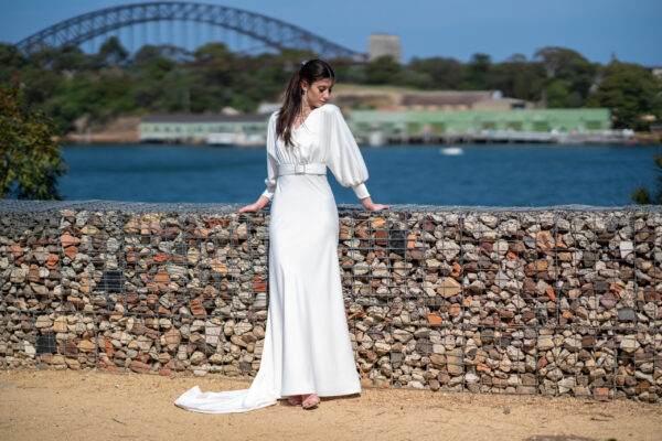 Woman posing in the stunning Erin wedding gown by Roya Javaheri