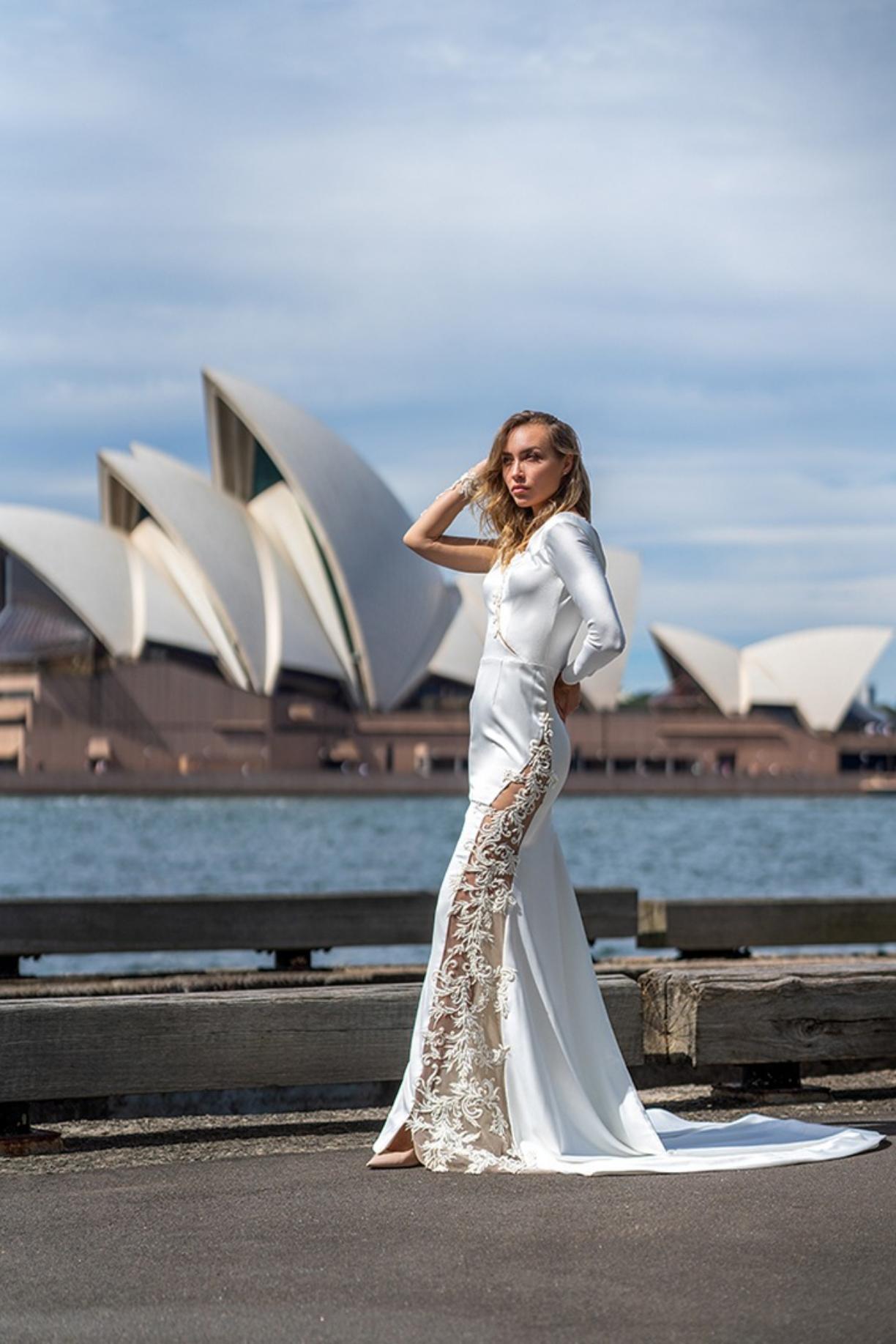 Woman posing in a stunning bridal gown in front of the Sydney Opera House