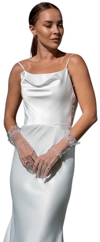 Woman posing in a simple, stunning bridal gown and wearing delicate gloves