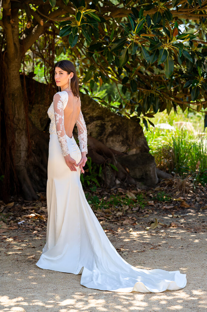 Back view of a long-sleeve wedding gown with an open lace back and train